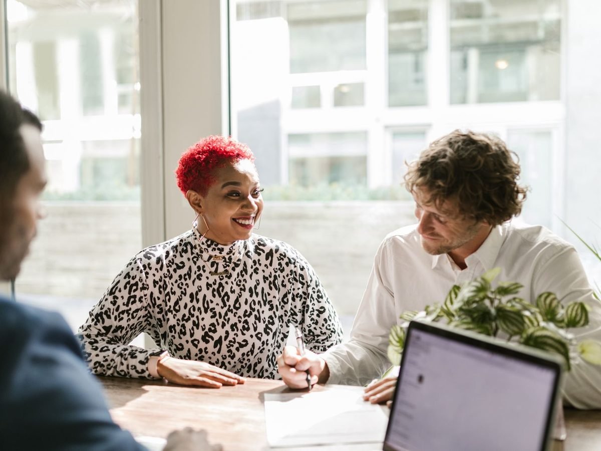 Smiling colleagues discussing a project at a bright table