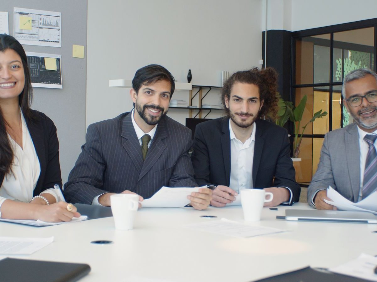 Smiling HR team seated around a meeting table with documents