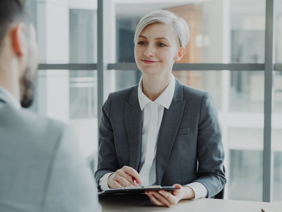 Smiling HR manager interviewing a candidate in a bright office