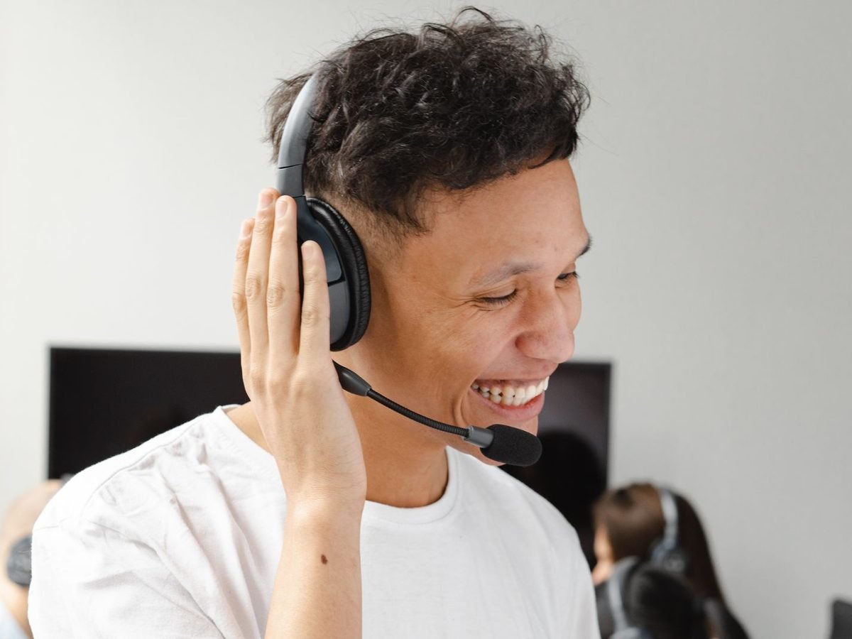 Smiling IT support agent wearing a headset at his desk
