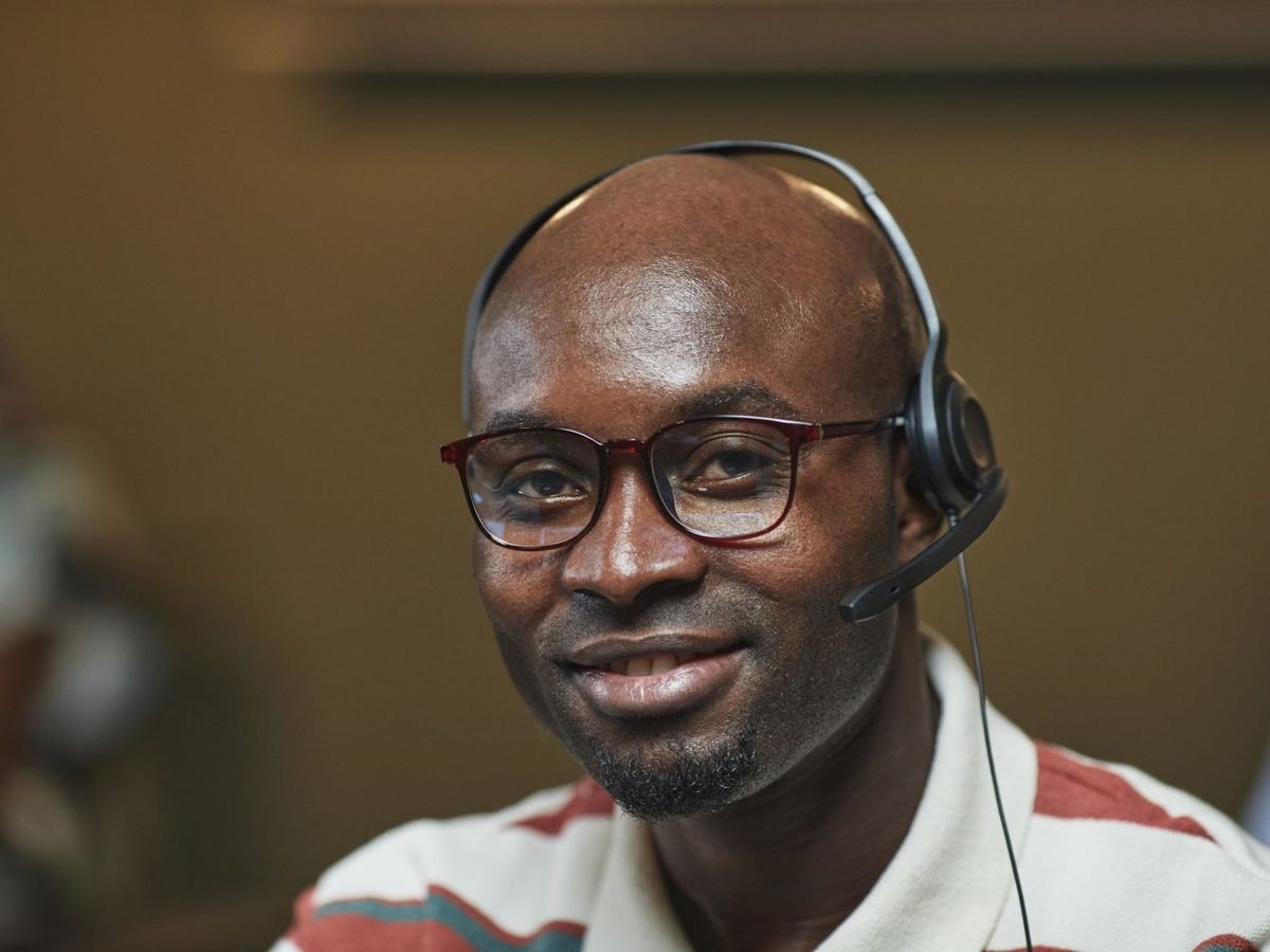 Smiling IT support specialist with glasses and a headset